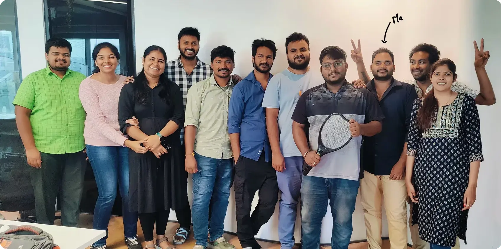 The Synclo team standing together in an office, with a handwritten 'Me' arrow pointing at Rahul.